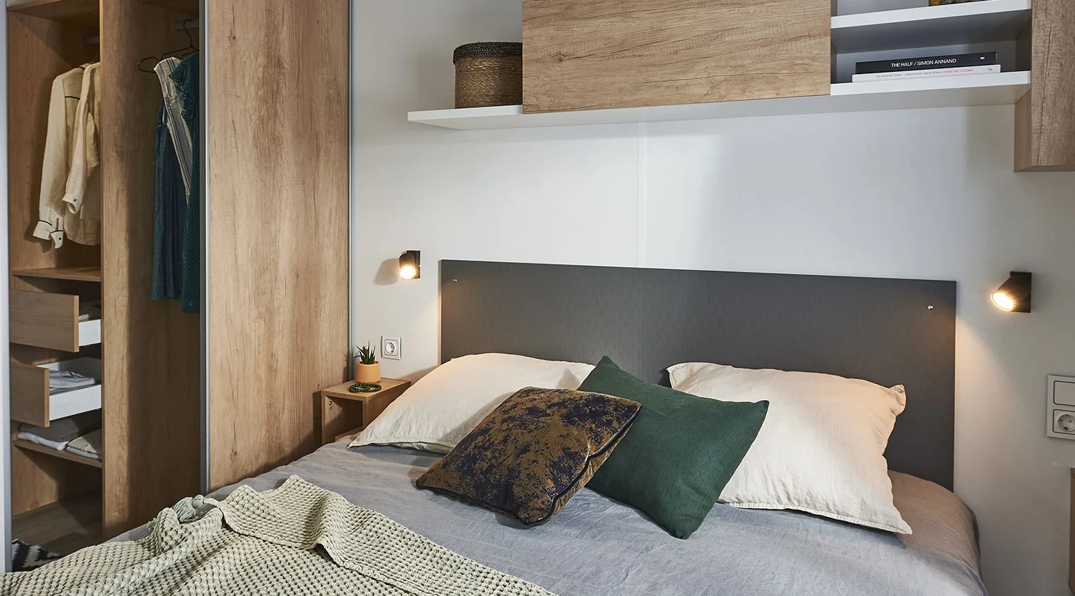 Chambre avec lit double et penderie ouverte dans un hébergement insolite vers Biarritz du Camping le ruisseau.