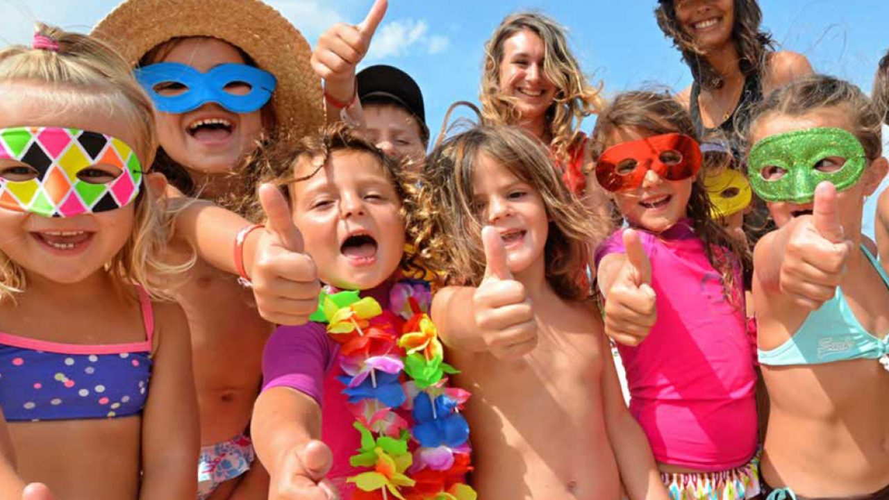 Enfants portant des masques colorés et faisant des pouces levés.