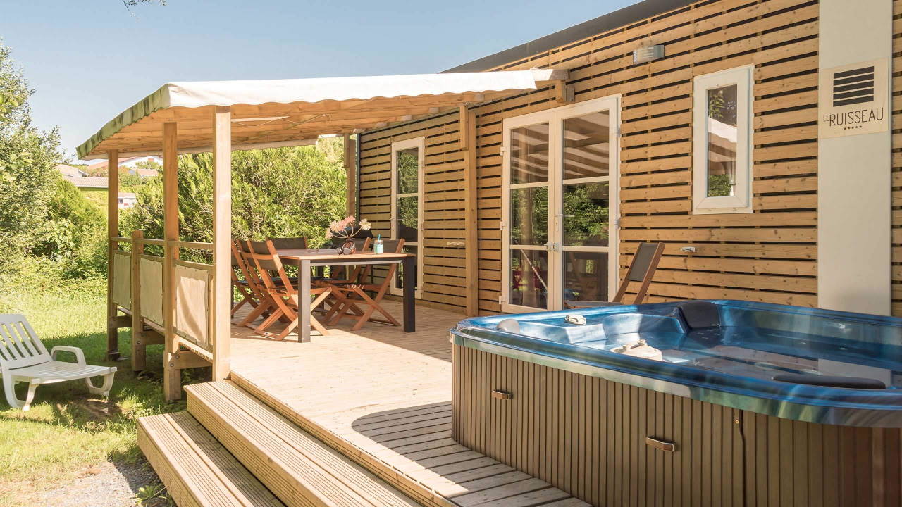 Mobil-home du Camping le ruisseau avec terrasse couverte et spa extérieur.