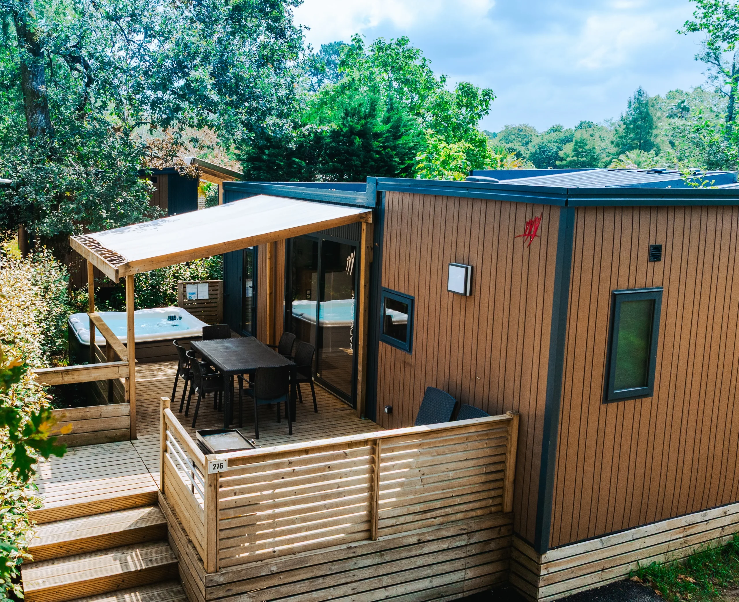 Terrasse en bois avec spa et espace repas d’un hébergement insolite vers Biarritz au Camping le ruisseau.