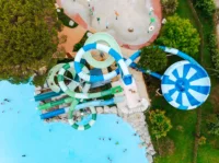 Vue aérienne des toboggans bleus et verts et de la piscine du Camping le ruisseau, camping à Bidart.