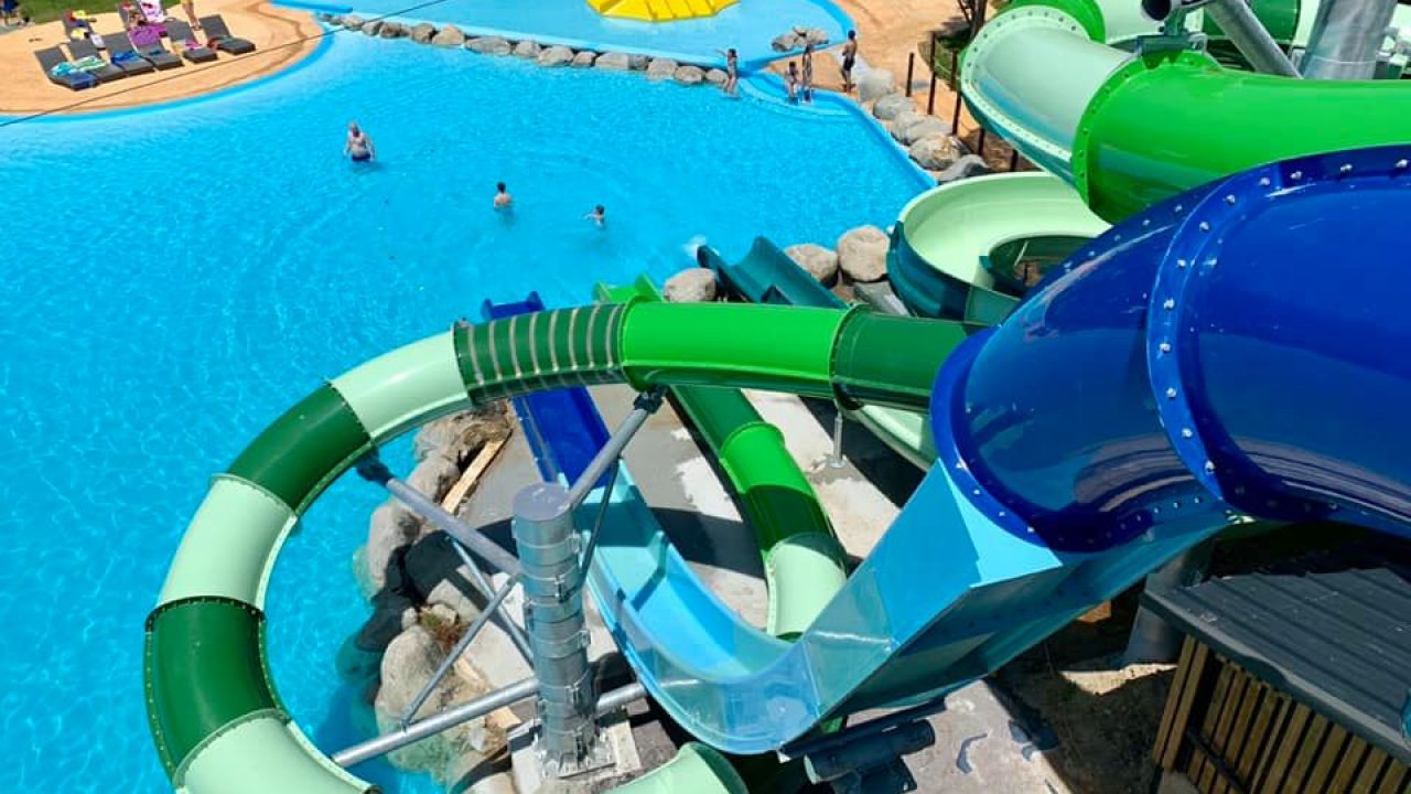 Toboggans aquatiques verts et bleus surplombant la piscine du Camping le ruisseau.