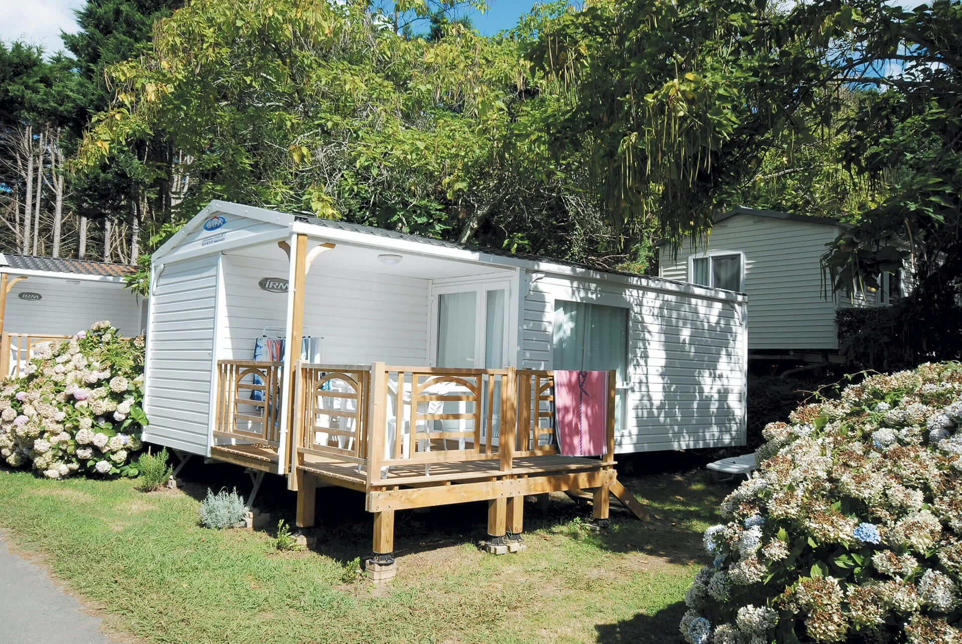 Mobil-home blanc avec terrasse couverte du Camping le ruisseau, un hébergement insolite vers Biarritz.