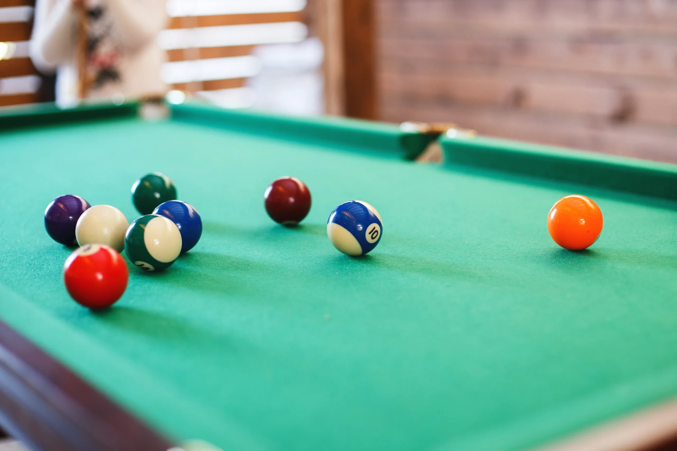 Billes de billard américain réparties sur le tapis vert d’une table.
