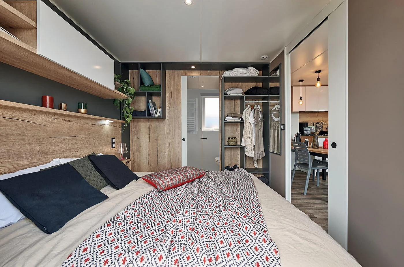 Chambre avec lit double et penderie ouverte d’un hébergement insolite vers Biarritz au Camping le ruisseau.