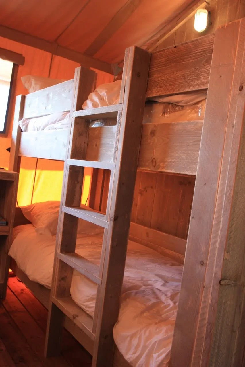 Lits superposés en bois avec échelle dans un hébergement insolite vers Biarritz au Camping le ruisseau.