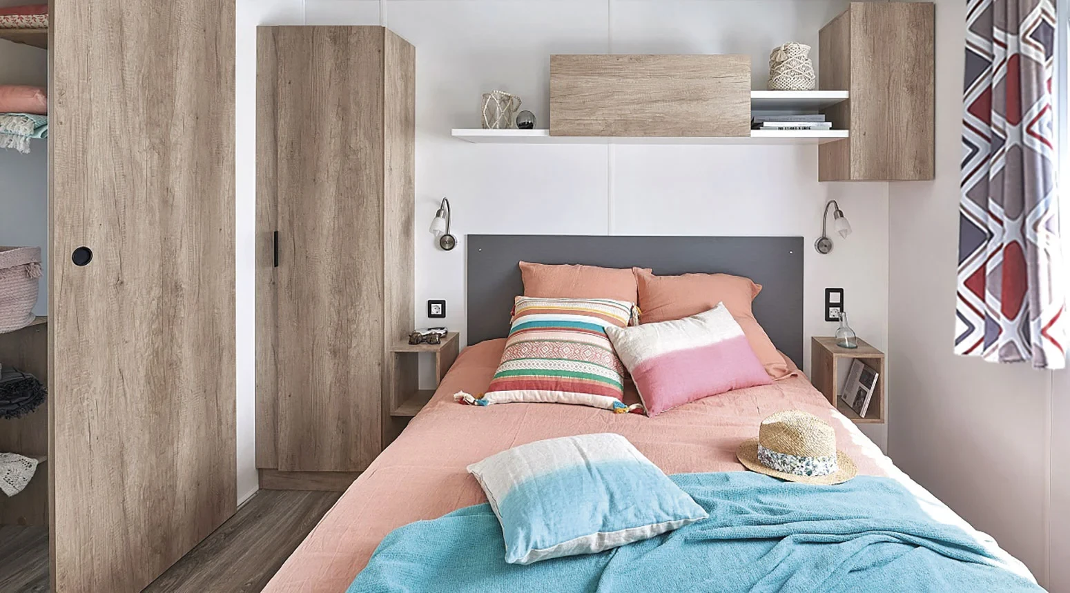 Chambre avec lit double et rangements en bois d’un hébergement insolite vers Biarritz au Camping le ruisseau.