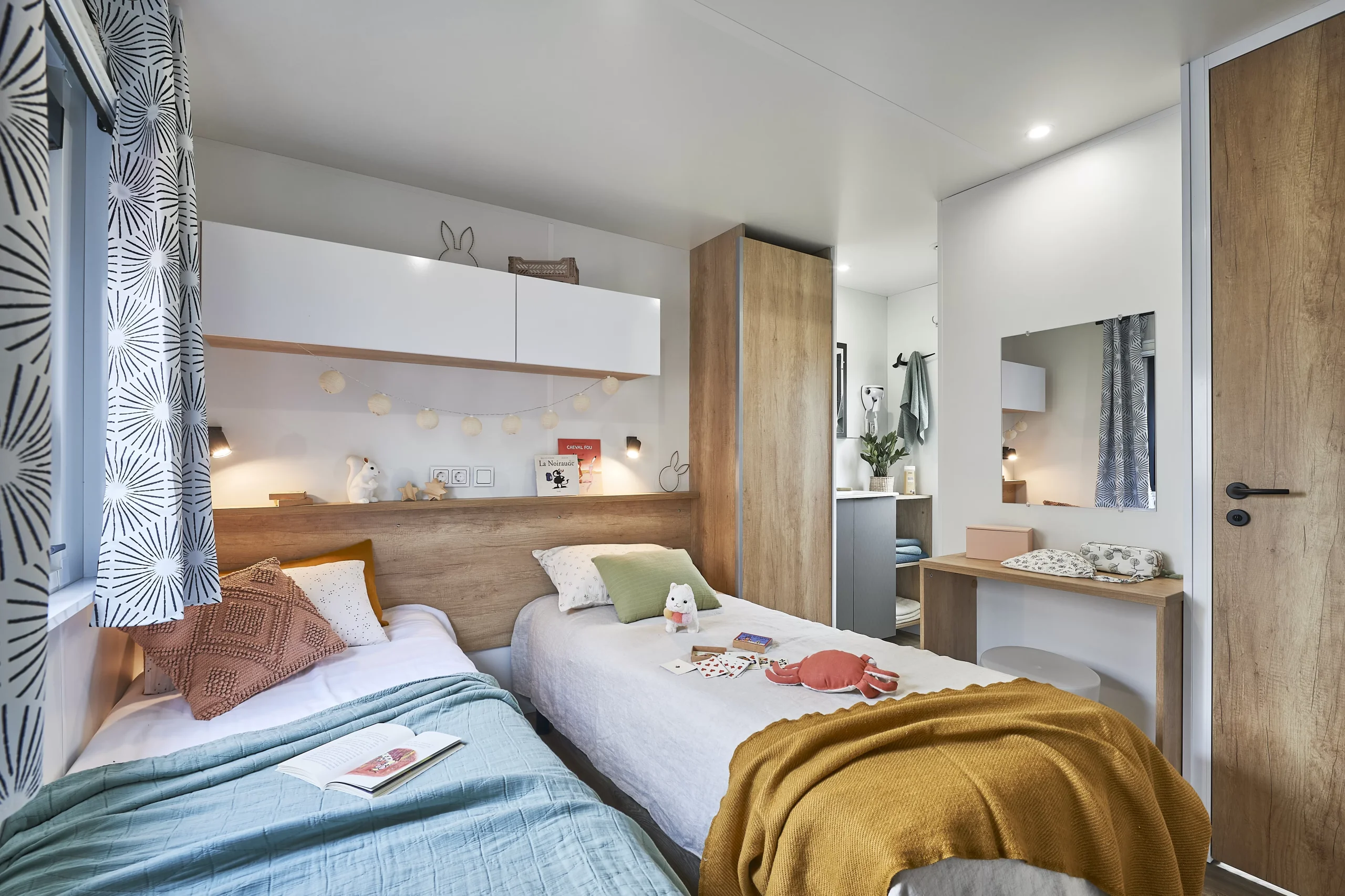 Chambre à deux lits simples d’un hébergement insolite vers Biarritz au Camping le ruisseau, avec rangements au-dessus des couchages.