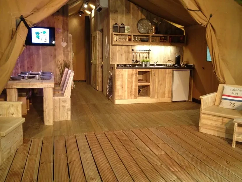 Coin repas et cuisine en bois sous la toile d’un hébergement insolite vers Biarritz au Camping le ruisseau.