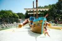 Enfants dans le bassin avec bateau pirate et toboggans du Camping le ruisseau, camping en bord de mer à Bidart.