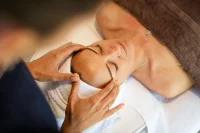 Femme recevant un massage des tempes dans l’espace bien-être du Camping le ruisseau.