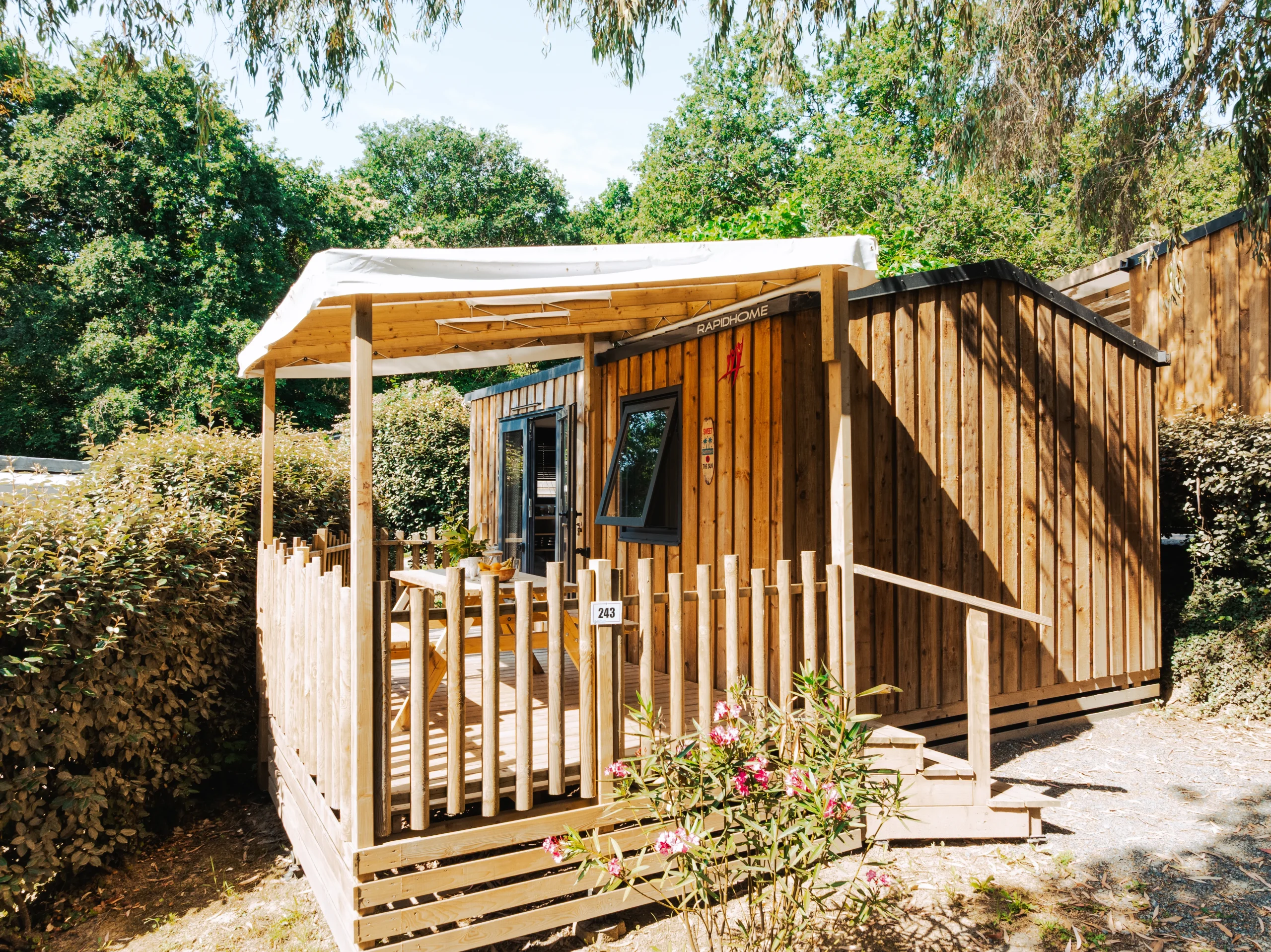 Cabane en bois avec terrasse couverte et accès par des marches, un hébergement insolite vers Biarritz du Camping le ruisseau.