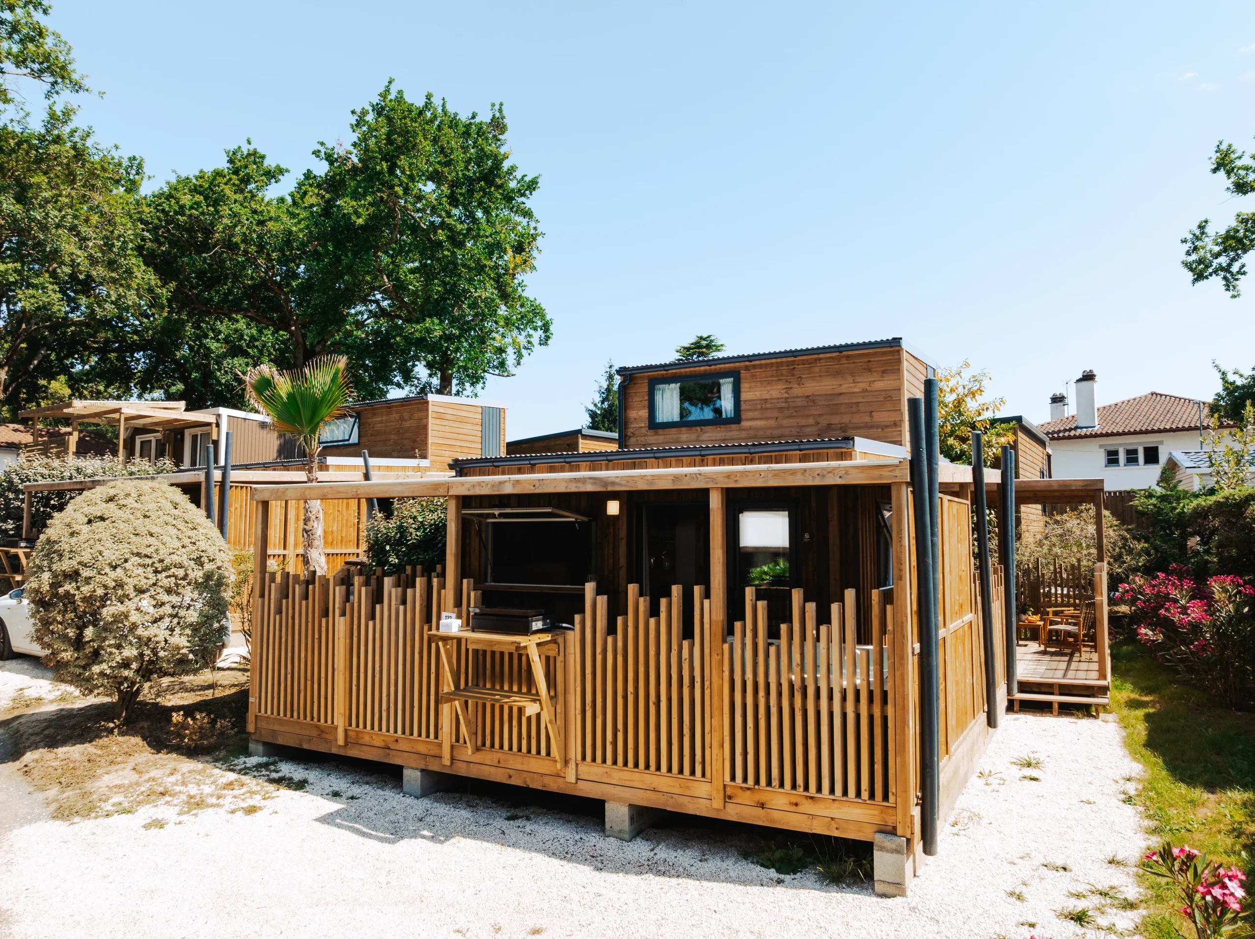 Hébergement insolite vers Biarritz du Camping le ruisseau, avec bardage en bois et terrasse couverte entourée d’une balustrade ajourée.