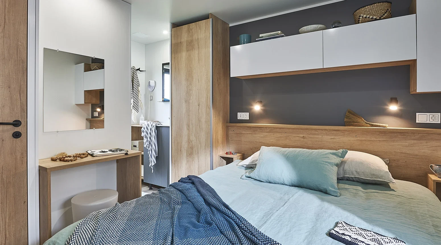 Chambre avec lit double et rangements au-dessus de la tête de lit dans un hébergement insolite vers Biarritz du Camping le ruisseau.